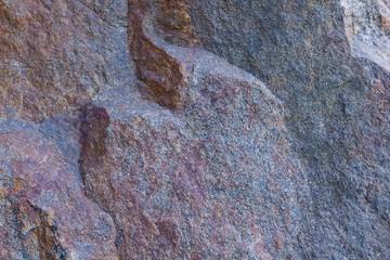Texture of granite close up. Granite rock with reddish color. Background from solid stone. Pattern with natural material