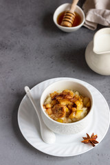Rice pudding or porridge and fruits (apple, pear, banana and raisins) with honey or maple syrup and spices. Healthy breakfast or dessert.  