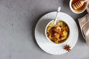 Rice pudding or porridge and fruits (apple, pear, banana and raisins) with honey or maple syrup and spices. Healthy breakfast or dessert.  