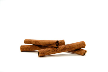 Dried cinnamon sticks isolated on white. Whole cinnamon sticks located on a white table. The concept of using seasonings for dishes. Eating spiced dishes.