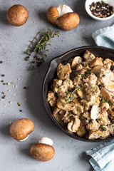 Meat stewed with mushroom and thyme in a cast-iron pan.  Grey concrete background. Copy space. 