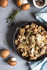 Meat stewed with mushroom and thyme in a cast-iron pan.  Grey concrete background. Copy space. 