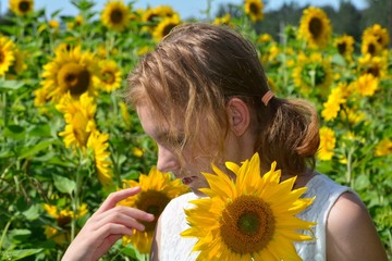 Mädchen mit Sonnenblume in der Natur und schaut nach unten