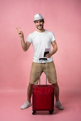 Man traveler with suitcase, passport and ticket on color background.