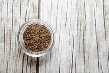 Cumin on a wooden background in a bowl. Cumin placed on the table. The concept of using seasonings for dishes. Eating spiced dishes.