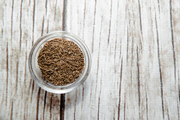 Cumin on a wooden background in a bowl. Cumin placed on the table. The concept of using seasonings for dishes. Eating spiced dishes.