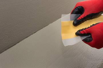 The worker shows how elastic and strong the waterproof tape is, sealing tape