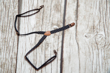 Children's blue suspenders. Children's braces for trousers on wooden background. The concept of supporting trousers so that they do not fall in children.