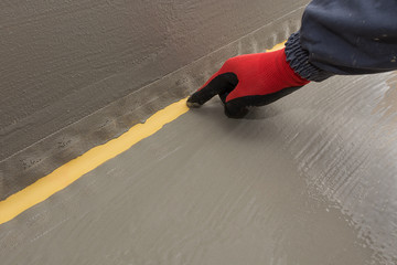 the worker shows the elastic part of the waterproof strip in the waterproofing system