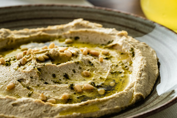 Delicious hummus with pine nuts and olive oil. Close-up.