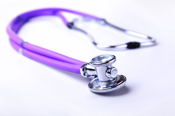 Medical stethoscope and red heart close-up on white background.