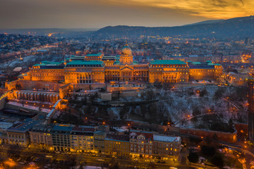 Budapest, Hungary - Aerial view of the snowy Buda Castle Royal Palace with beautiful golden sunset on a winter afternoon