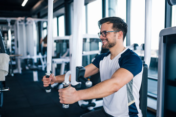 Smiling young man working out in the gym.