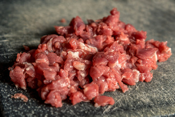 finely chopped red meat on a wooden board