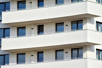Modern white building with balcony on a blue sky