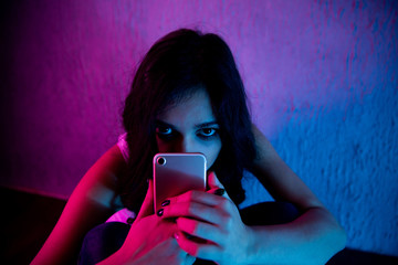 scared and sad female teenager with computer laptop suffering cyberbullying and harassment being...