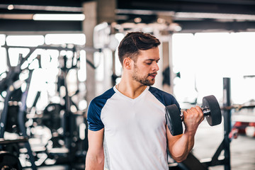 Determined young man working out in gym.