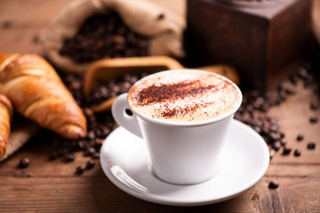  coffee cup close-up over dark roasted coffee beans