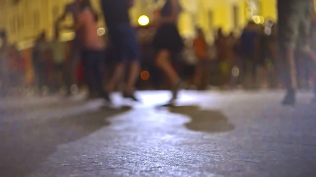 Defocused couples on background dancing salsa in the street