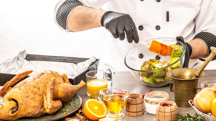Chef hands cooking duck stuffed with apples. Food concept