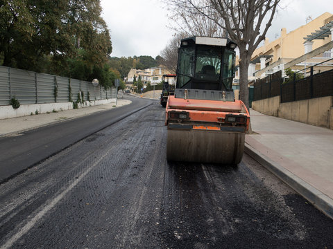M&aacute;quina apisonadora de asfalto que apila y presiona asfalto caliente. M&aacute;quina de reparaci&oacute;n de camino. Reparaci&oacute;n en ciudad moderna.