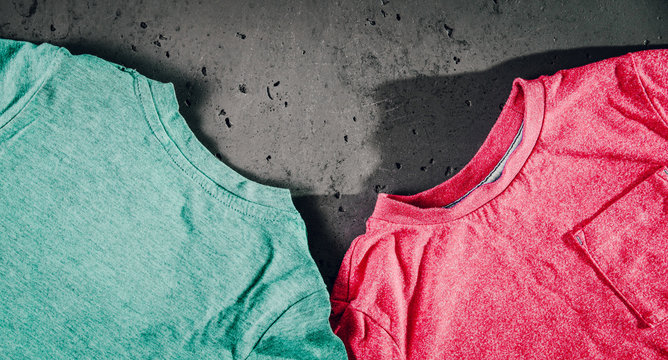 Top view of a children's red blouse, shirt and blue on stone background. The concept of children's clothes.