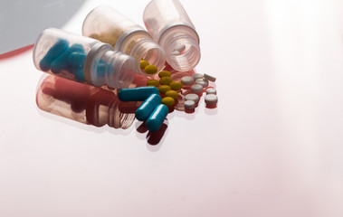 Assorted pharmaceutical medicine pills, tablets and capsules. Red background.