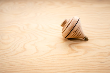 Traditional toy called spinning top made of wood with metal end.