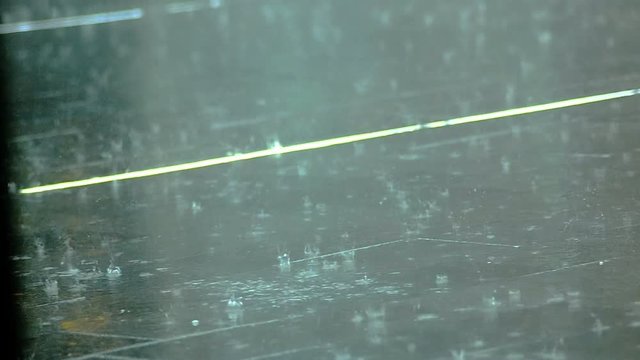 Rain drops on asphalt and running feet