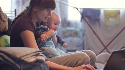Mother with her baby using laptop
