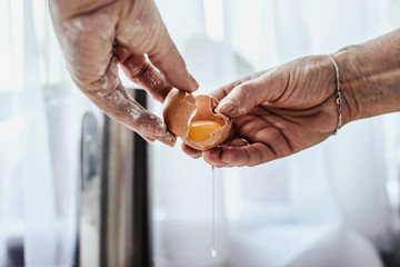 A woman smashes an egg, uses a yolk. Punching eggs for cake preparation. Concept of baking and preparing a cake for baking. Adding eggs as an ingredient to the dough. Baking gingerbreads.