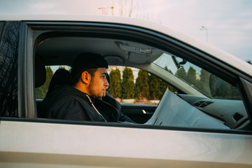 Thieves parked in an ally waiting while observing their target and loading their guns.