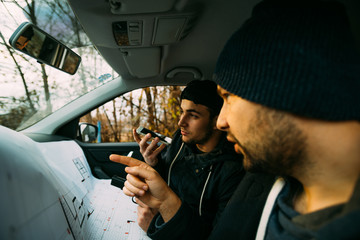Two armed bandits sitting in a car planning their next robbery, while counting on a stopwatch the...