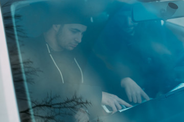 Thieves parked in an ally waiting and planning the way they will rob their target.