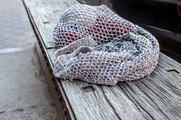 Obraz premium String bag with various knitting yarn on old wood bench