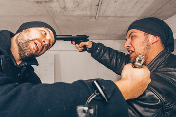 Man in black pointing a gun