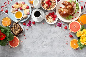Breakfast food table. Festive brunch set, meal variety with pancakes, croissants, juice, fresh berries, granola and fresh fruits. Easter breakfast. Top view with copy space.