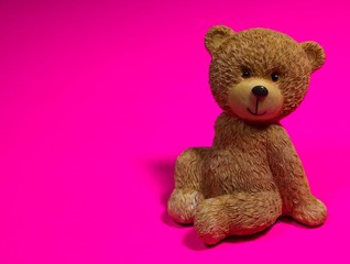 brown teddy bear on pink background