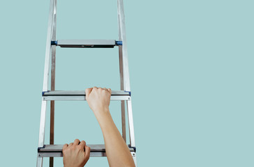 Hands climb the ladder on blue pastel background. The hard way to succeed, the concept of hard work to get promoted. Career path, gaining happiness.