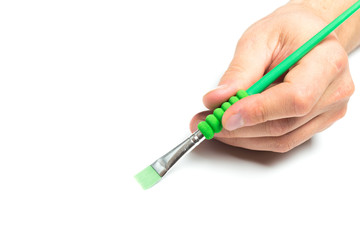 Men's hand holding color brush on isolated backgroung, close up