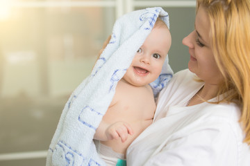 Young infant boy kissing with mother at home