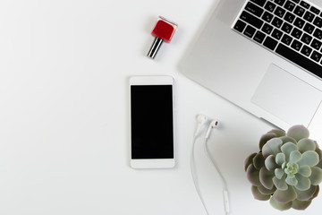 Top View of trendy White Office Desk with keyboard, white earphones and office supplies.