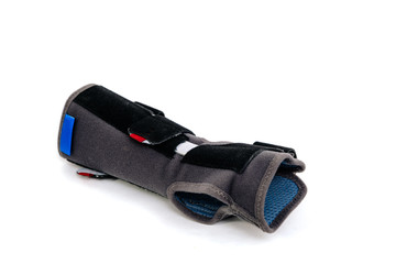 A black orthosis on a hand lies on a white background. Medicine and health concept, treatment of problems with hand, pain in the wrist and joints. Insulated orthosis on hand,