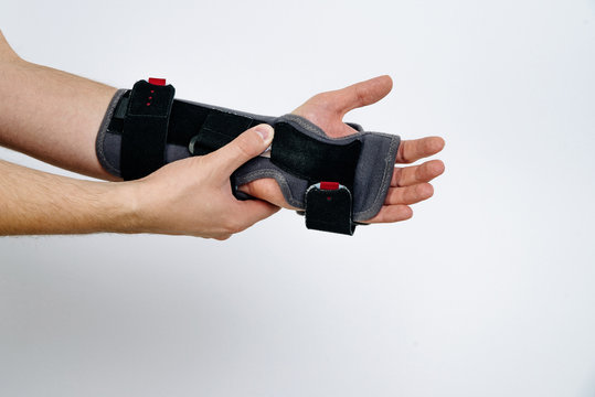 A black orthosis put on his arm. Medicine and health concept, treatment of problems with hand, pain in the wrist and joints. Insulated orthosis on hand, help in fractures instead of plaster.