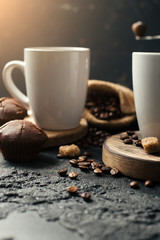 Black fried coffee beans in cafe with cookie and cake on dark textured background