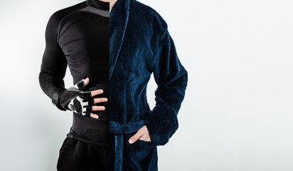 A man dressed in half in sports clothes and in a bathrobe on white background. The concept of practicing sports, playing sports instead of resting, resting after the gym.