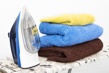 iron with clothes on the ironing board