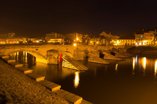 Night winter oldest stone bridge in central Europe above River Otava, Pisek, Czech Republic