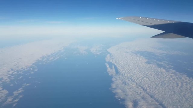 White clouds looking like a snowy field from airplane window on a sunny day