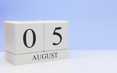 August 05st. Day 5 of month, daily calendar on white table with reflection, with light blue background. Summer time, empty space for text